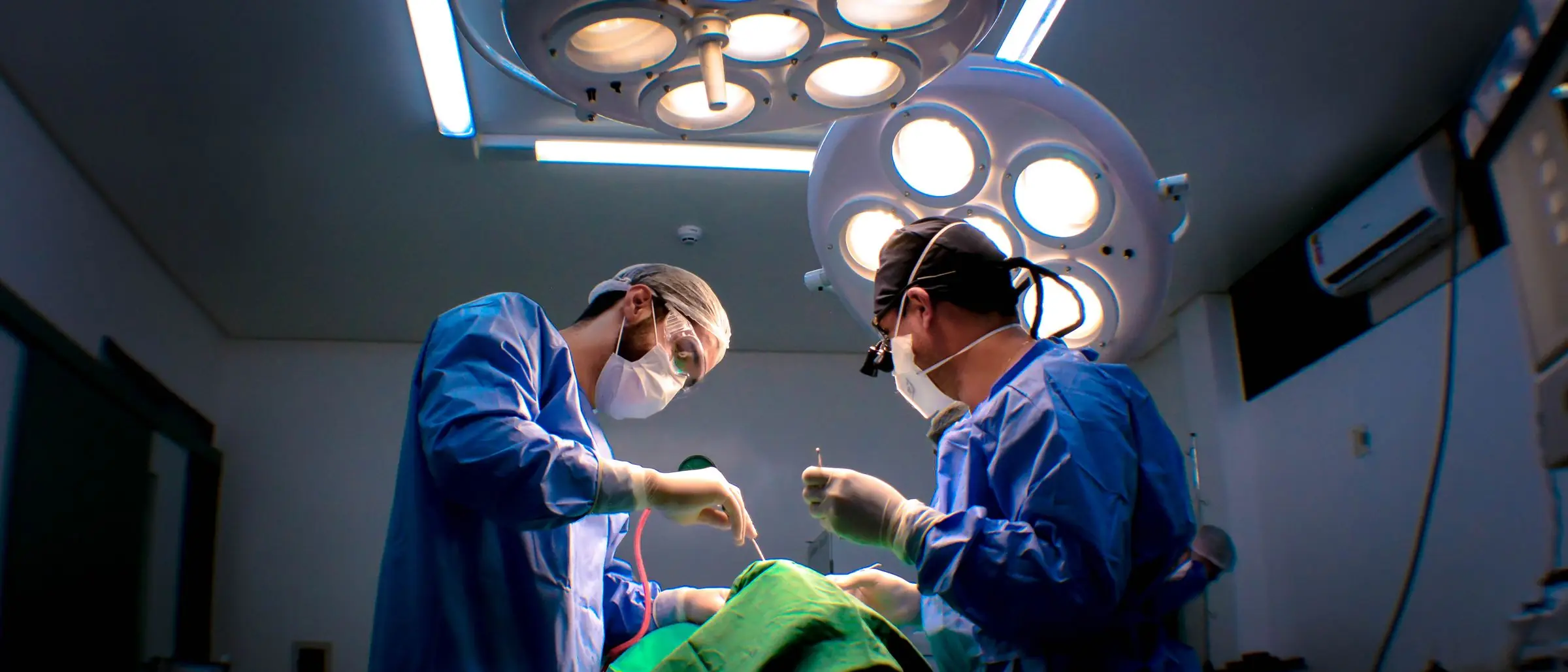 Cirujanos urólogos operando bajo las lámparas de un quirófano en Tijuana